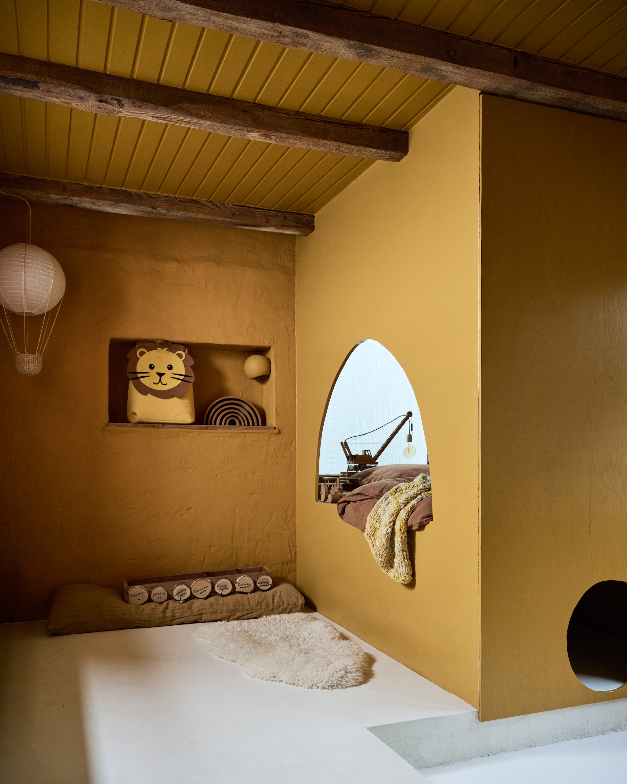 Plafond- en muurverf Racing Riksja van Lab Paint. Schapenvacht Vacht van Vilt. Plaid en speelgoedleeuw gekregen van oma. Speelgoedtrein zelfgemaakt. Speelgoedregenboog Grimm’s. vtwonen 12-2025 | styling Marianne Luning | fotografie Sjoerd Eickmans