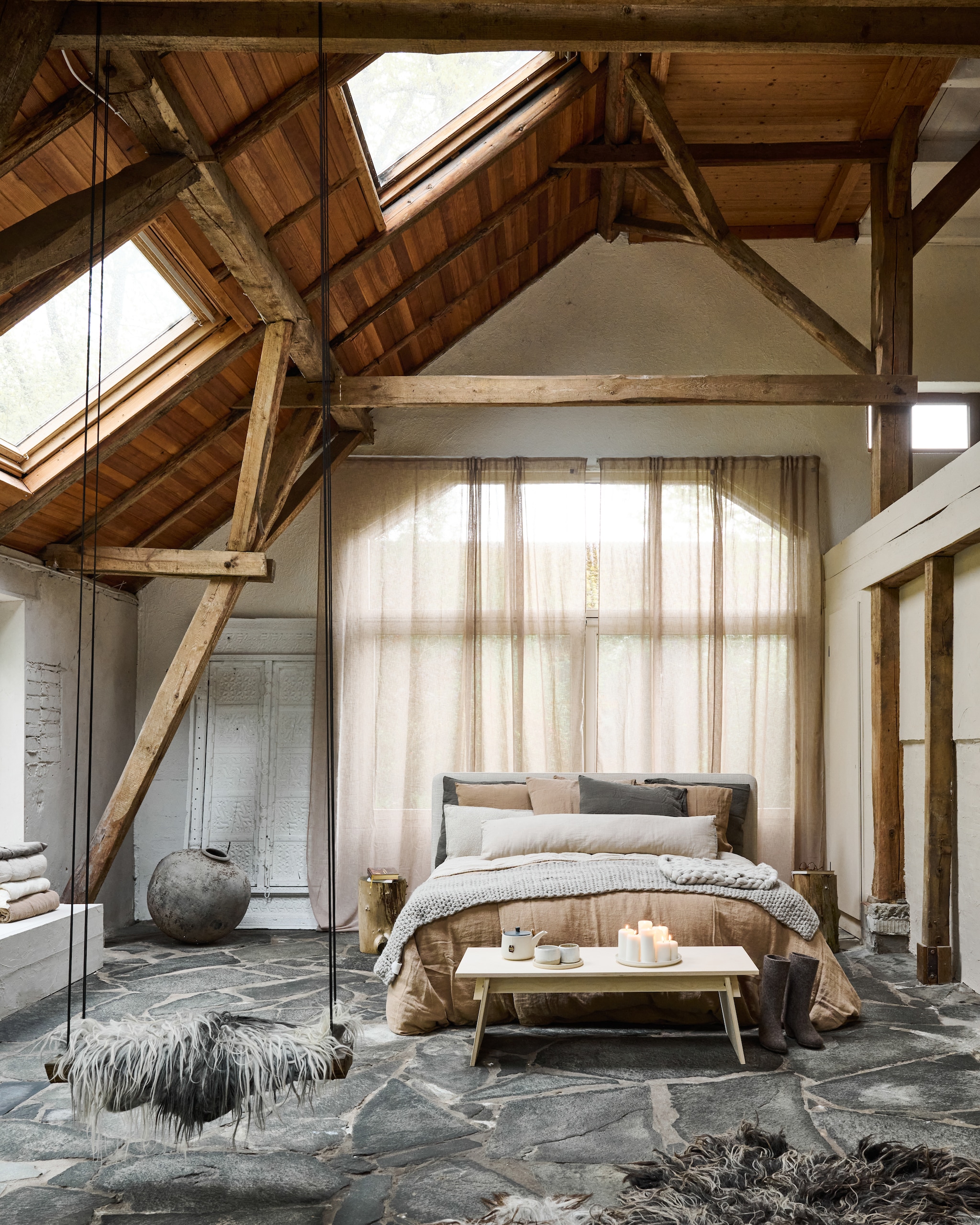 Bijzettafel voeteneind Fuyu van Grimm’s. Bijzettafels naast bed boomstammen uit eigen tuin. Theepot kringloop. Kopjes Akm keramiek. Kaarsen Ikea. vtwonen 12-2025 | styling Marianne Luning | fotografie Sjoerd Eickmans