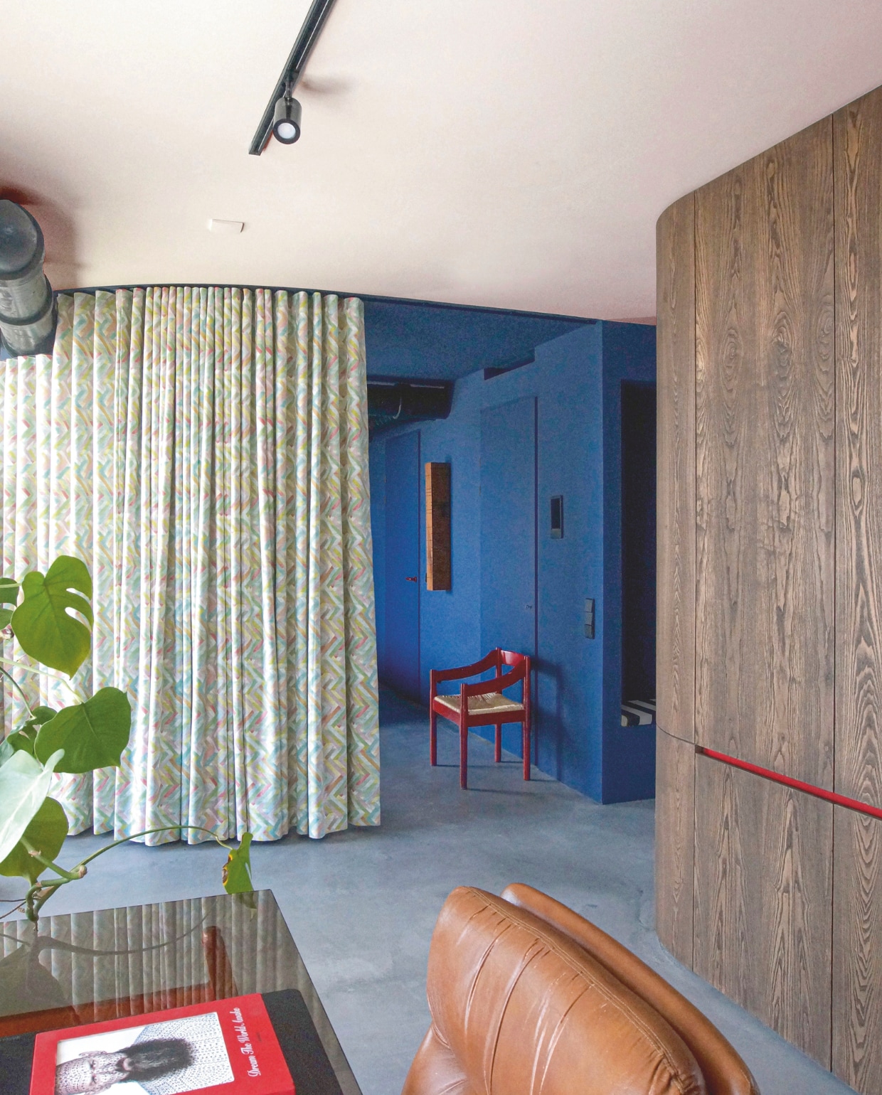 Het slaapgedeelte wordt afgeschermd met een zware gordijnstof. Kies een grafisch patroon: dat trekt de aandacht. Stijlvol Wonen 8-2025 | Styling & Fotografie Bart Wigger | Tekst Evelien Roels