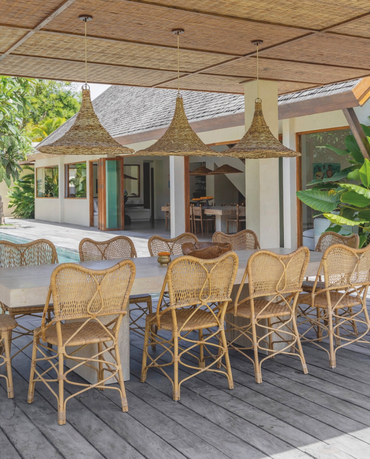 De travertin tafel werd op maat gemaakt en de stoelen van Balinees bamboe zijn praktisch in gebruik en bestand tegen natte zwembroeken. vtwonen Landelijk 8-2025 | fotografie Sheila Man | tekstbewerking Marie Masureel