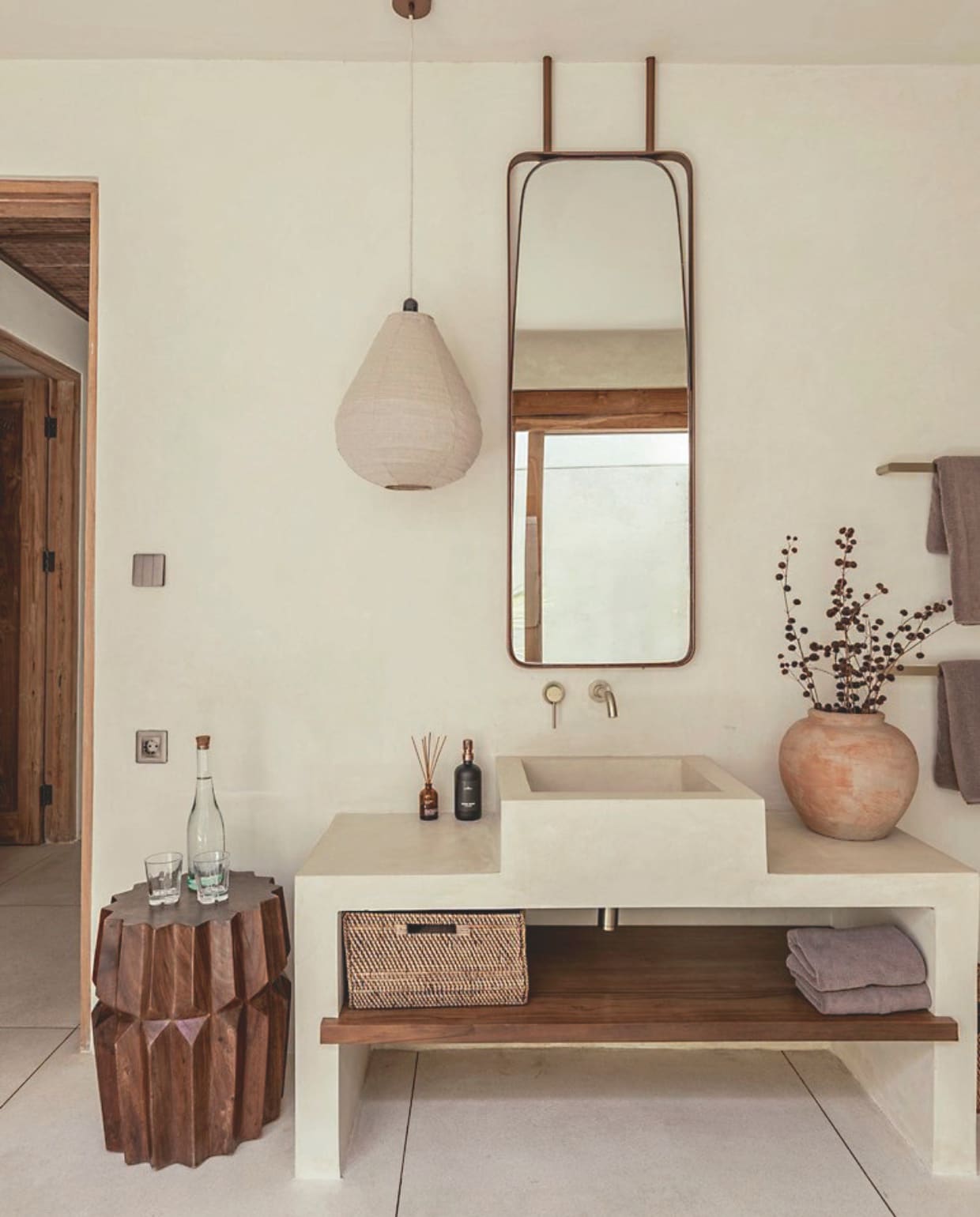 Her en der staan houten krukjes die gebruikt worden als bijzettafeltje of nachtkastje. De kruiken komen van een lokale markt. Van sommige liet Zoe sfeerlampen maken. vtwonen Landelijk 8-2025 | fotografie Sheila Man | tekstbewerking Marie Masureel