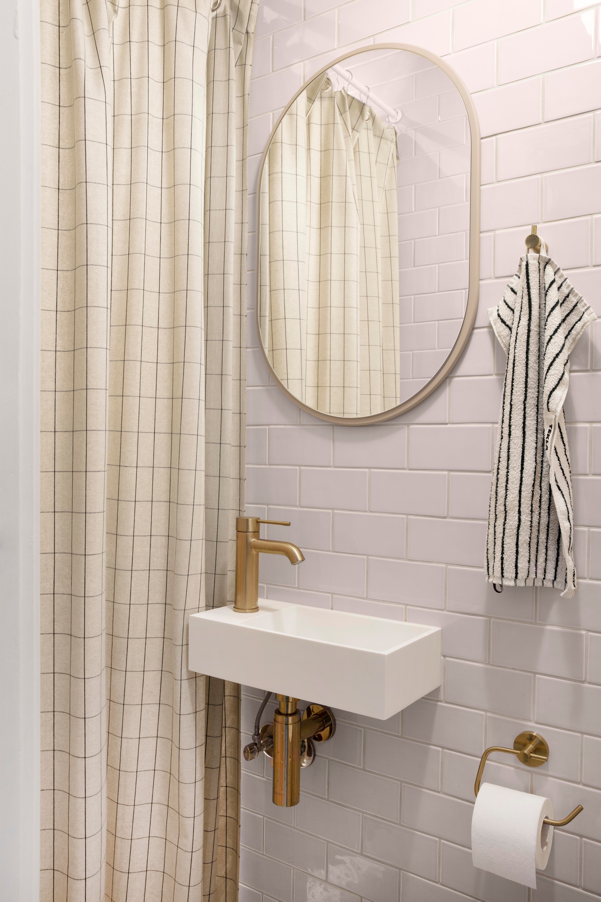 Wasbak, toiletrolhouder Grohe. Spiegel Montana furniture. Handdoek Tekla Fabrics. vtwonen 01-2026 | productie Living Inside | styling Rikke Graff Juel | fotografie Christina Kayser O.