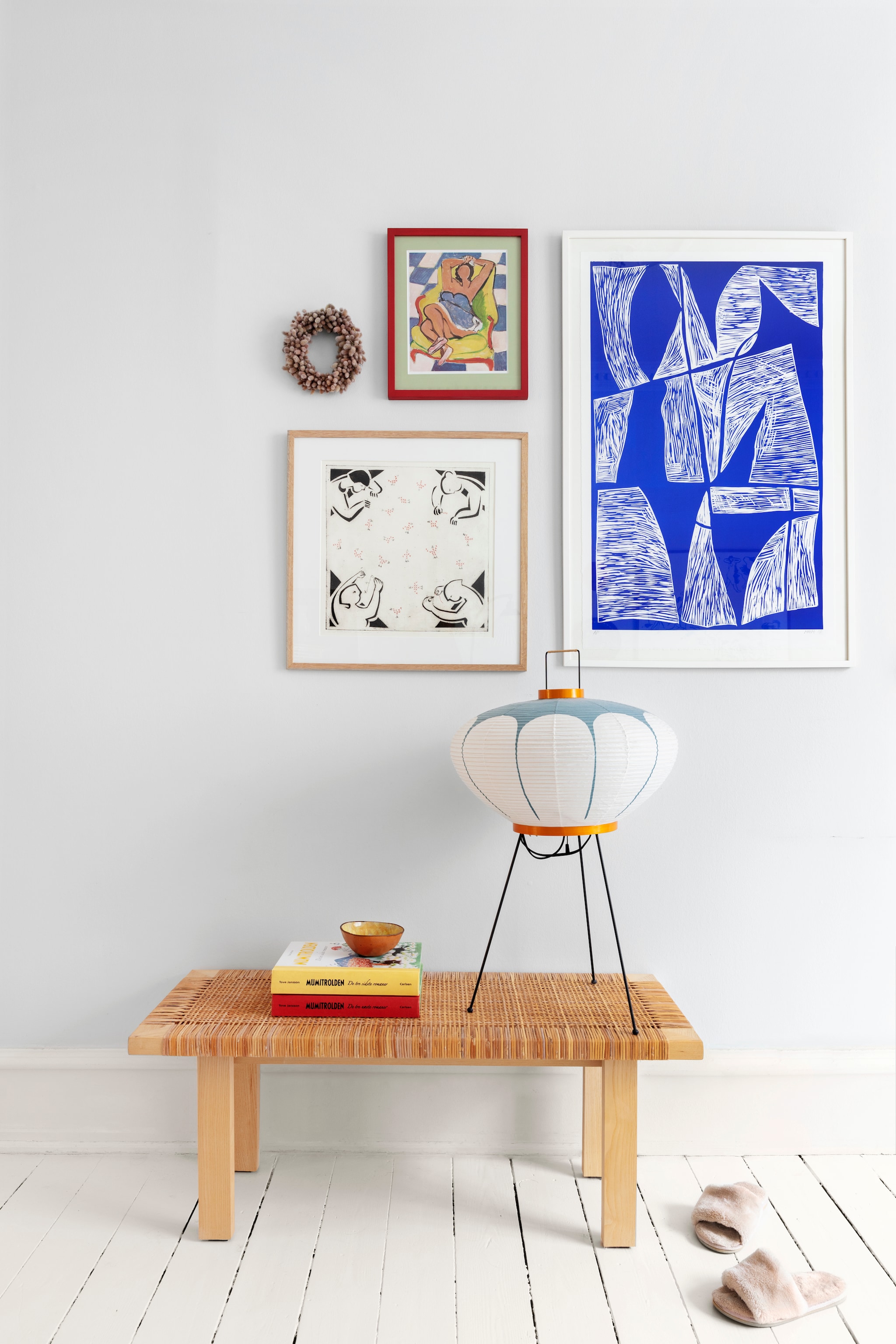 Bankje Ikea. Lamp Akari 9ad van Isamu Noguchi. Kunstwerk linksonder Ida Mortensen. Kunstwerk blauw Mathias Malling Mortensen. Kleine print Picasso. vtwonen 01-2026 | productie Living Inside | styling Rikke Graff Juel | fotografie Christina Kayser O.