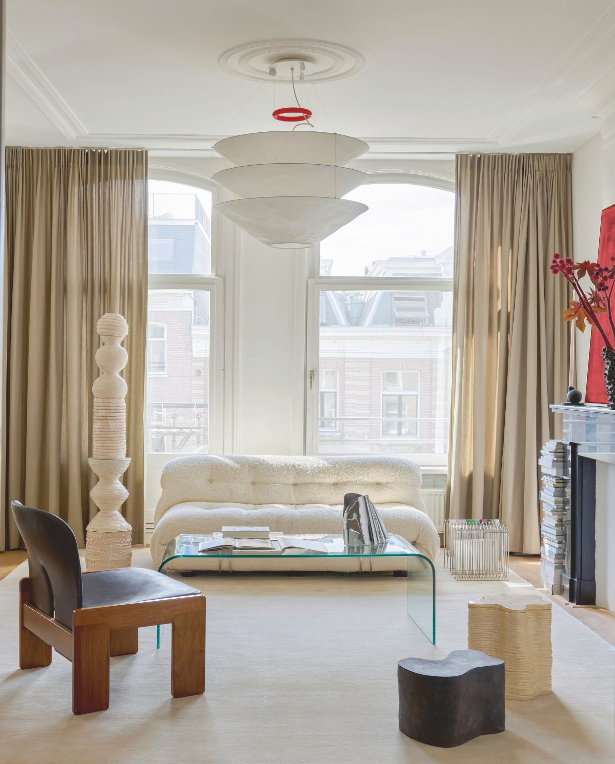 Bank Soriana van Cassina. Lamp Floatation van Ingo Maurer. Metalen magazinerek Aytm. De salontafel vond Gloria online. Zilveren vaas Georg Jensen. Totem en krukken 2222Studio. Vintage feauteuil Scarpa 925 van Afra en Tobia Scarpa via Objekt Vintage. De gordijnen hingen er al. Stijlvol wonen 9-2025 | styling Marianne Luning | fotografie Kasia Gatkowska | tekst Anneleen Peeters