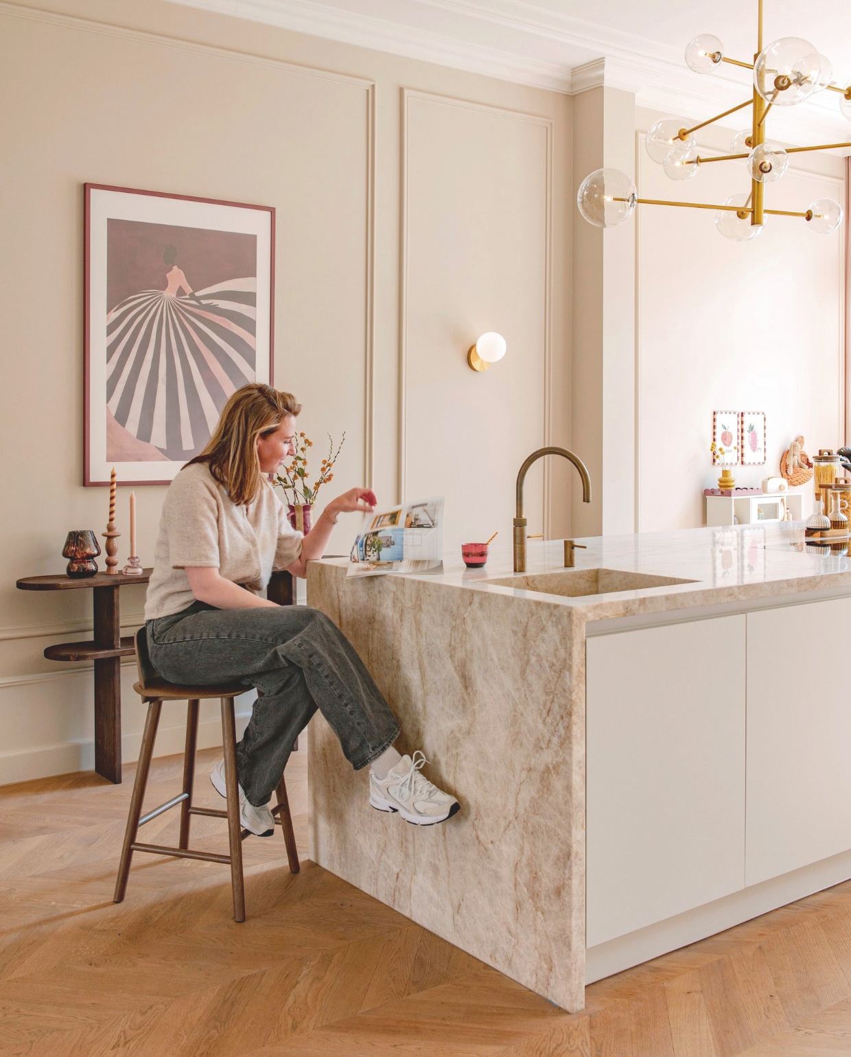 Keuken Mugg Kitchens. Kwartsiet blad Jan Reek natuursteen. Kraan Quooker. Kroonluchter Eichholtz. Barkruk Muuto. Wandlamp Bazaaronline. Sidetable zelfgemaakt. Tafellamp Action. Kandelaars By-boo en Hema. Vaas Things I Like Things I Love. Kopje Hkliving. Print Etsy. Geoliede eiken vloer in Hongaarse punt. Verfkleur muur Petit Macaron van Lab Paint. vtwonen 10-2025 | fotografie Caroline Coehorst | tekst Chris Muyres