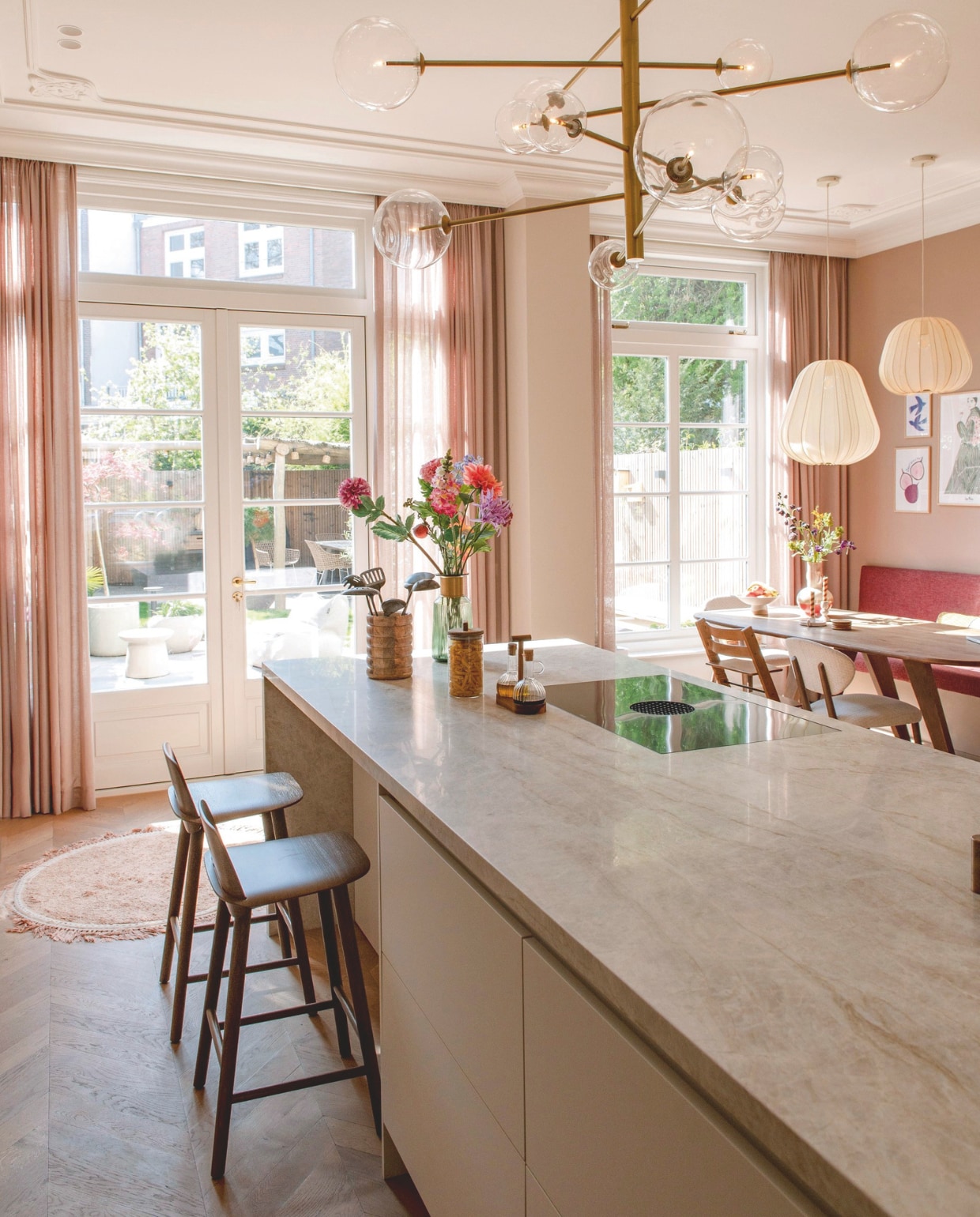 Plafondornamenten en sierlijsten Het Schippertje. Gordijnen Holland Haag. Eettafel Lopped Butik. Lampen erboven Bolia. Stoel TrippTrapp van Stokke. Eetkamerstoel Mobitec. Bank op maat gemaakt. Vaas Trendhopper. Kandelaars Xenos. Rond vloerkleed Tapis Petit. Tuinmeubels The Garden Store. Vaas op aanrecht Kare Design. Oliestel Zara Home. Kookplaat Bora. Pot Things I Like Things I Love. vtwonen 10-2025 | fotografie Caroline Coehorst | tekst Chris Muyres