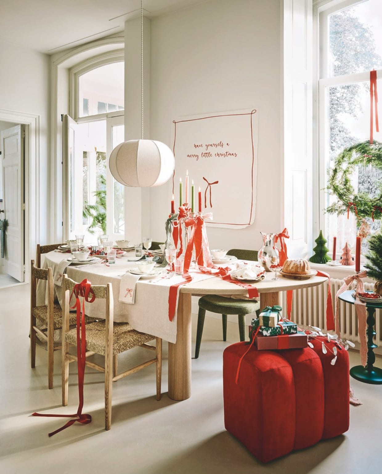 Firma Hout en Staal eettafel, eikenhout, 250x110x76 cm (lxbxh) vanaf € 1728,-, poef, rood € 250,- (loods5.nl). Zara Home stoel, essenhout en zeegras, 43x43x82 cm (bxdxh) € 189,-, hanglamp, katoen, wit, 48x24,5 cm (Øxh) € 79,99, servies, porselein, groen, per stuk vanaf € 6,99, waterglazen € 3,99, wijnglazen € 3,99, tafelkleed, linnen € 69,99, kandelaar, porselein, groen € 11,99 (zarahome.com). Polspotten eetkamerstoel Cosy, forest green, € 400,-, bijzettafel Classic, metaal, groen € 260,- (polspotten.com). Kulu Club servetten, linnen met geborduurde strik, set van 2 € 23,95. The Green Home Company kerstboom met kluit € 26,95, Urban Nature Culture schaal op pootjes, hout € 34,99. vtwonen ring met krans € 29,95 (shop.vtwonen.nl). Tableware Amsterdam bestek, antiek, zilver, per couvert € 45,-, kandelaar, verzilverd € 75,-, dienblad, verzilverd € 20,-, coupe, rvs € 12,50 (tableware.amsterdam). H&m karaf, rvs € 39,99, theedoek, groen-wit € 4,99 (hm.com). Mo-ca home poster, canvas, eigen ontwerp gedrukt, vanaf € 16,95 (mo-cahome.com).Bungalow kerstornamenten, bomen, papier, groen en roze, per stuk vanaf € 10,-, mistletoe, metaal € 47,50 (bungalow.dk). Søstrene Grene geschenkdoos, papier, rood-roze € 4,18 (sostrenegrene.com). Overig privébezit. vtwonen kerstboek 2025 | styling Danielle Verheul | fotografie Sjoerd Eickmans