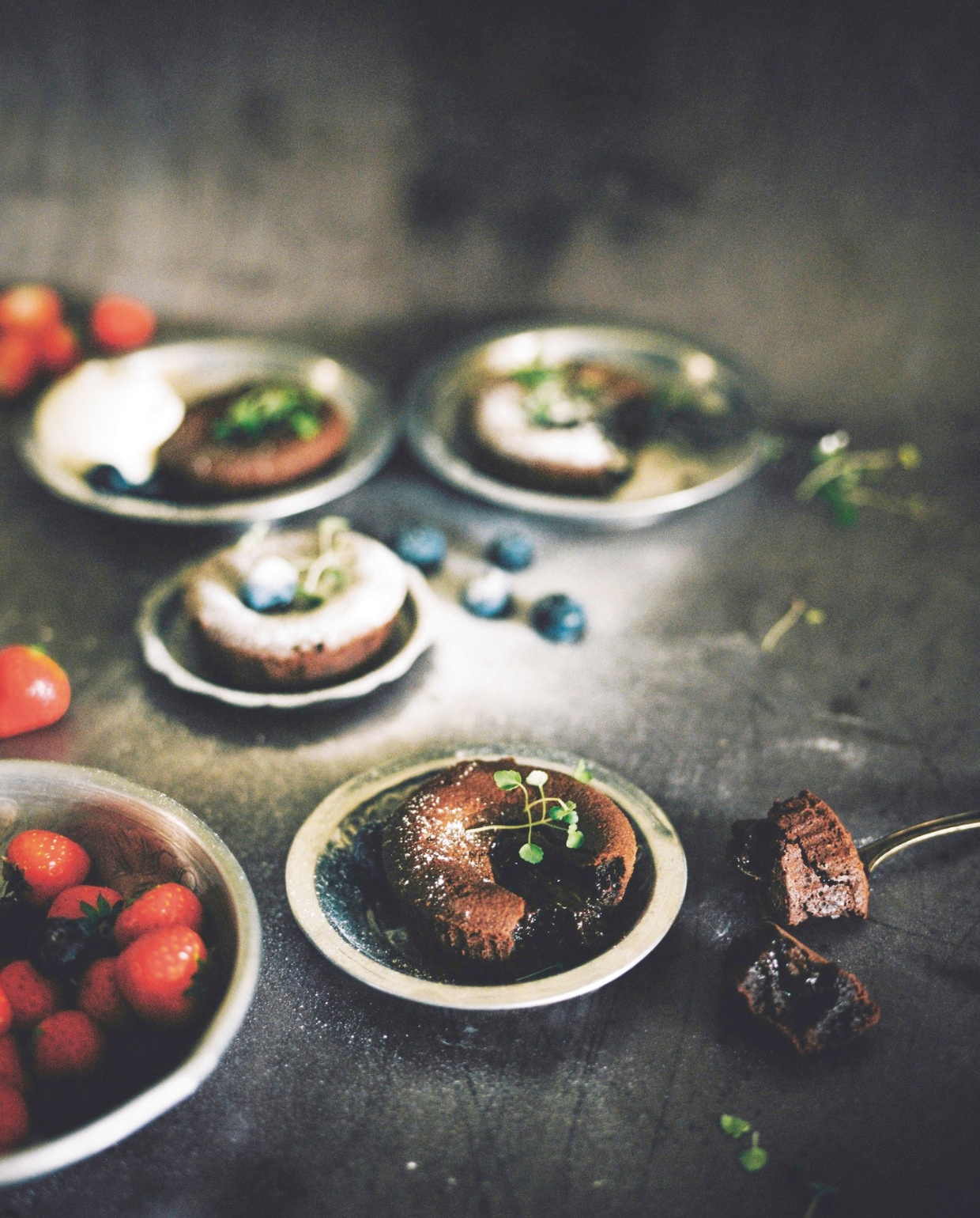 Voor chocolade- en toetjesfans zijn deze warme, smeuïge chocoladetaartjes onweerstaanbaar. Een heerlijke afsluiter van een feestelijk diner. Maak het beslag van tevoren en bak de taartjes vlak voor het serveren. vtwonen kerstboek 2025 | recepten The Holy Kauw | fotografie Hanke Arkenbout
