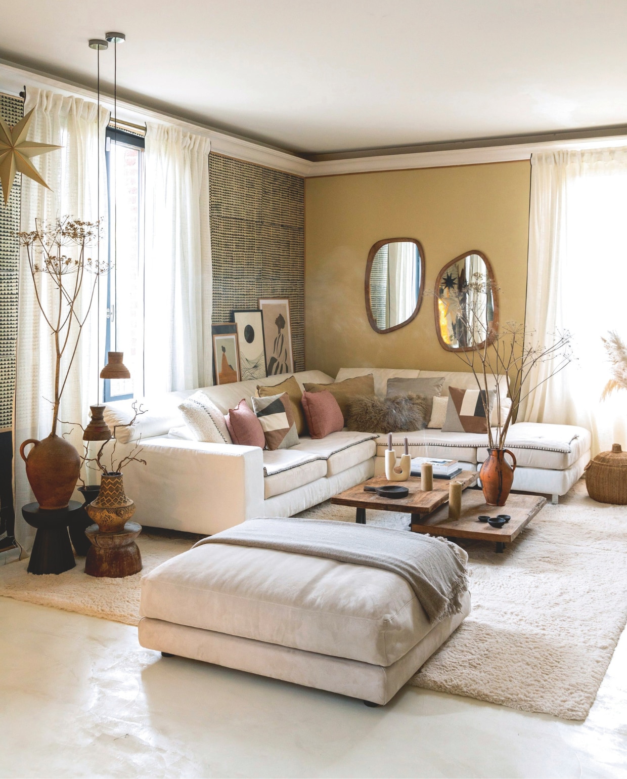 Gepolijste betonnen vloer in Isatis van Maison Étanche. Muurverf Sarrasin van Pure & Paint. Behang Le Monde Sauvage. Bank en hocker Poltronesofà. Kussens Maison de Vacances en La Redoute. Wollen plaid Maison de Vacances. Vloerkleed Decoweb. Spiegels Made in Meubles. Illustraties Gallerix. Gordijnen Easeease Curtains. Hanglampen Boutique Brut. Salontafels gemaakt door Eve, poten van La Fabrique des Pieds. Kandelaars H&m Home. Kaarsen Ciergerie des Prémontrés. Zwarte accessoires Atmosphera en Floraux. Stenen vaas en bijzettafels Leboncoin. Vaas en kruik vlooienmarkt. vtwonen Landelijk kerstspecial 2025 | styling Marie-Maud Levron | fotografie Cecile Perrinet Lhermitte  | tekstbewerking Britte Kramer