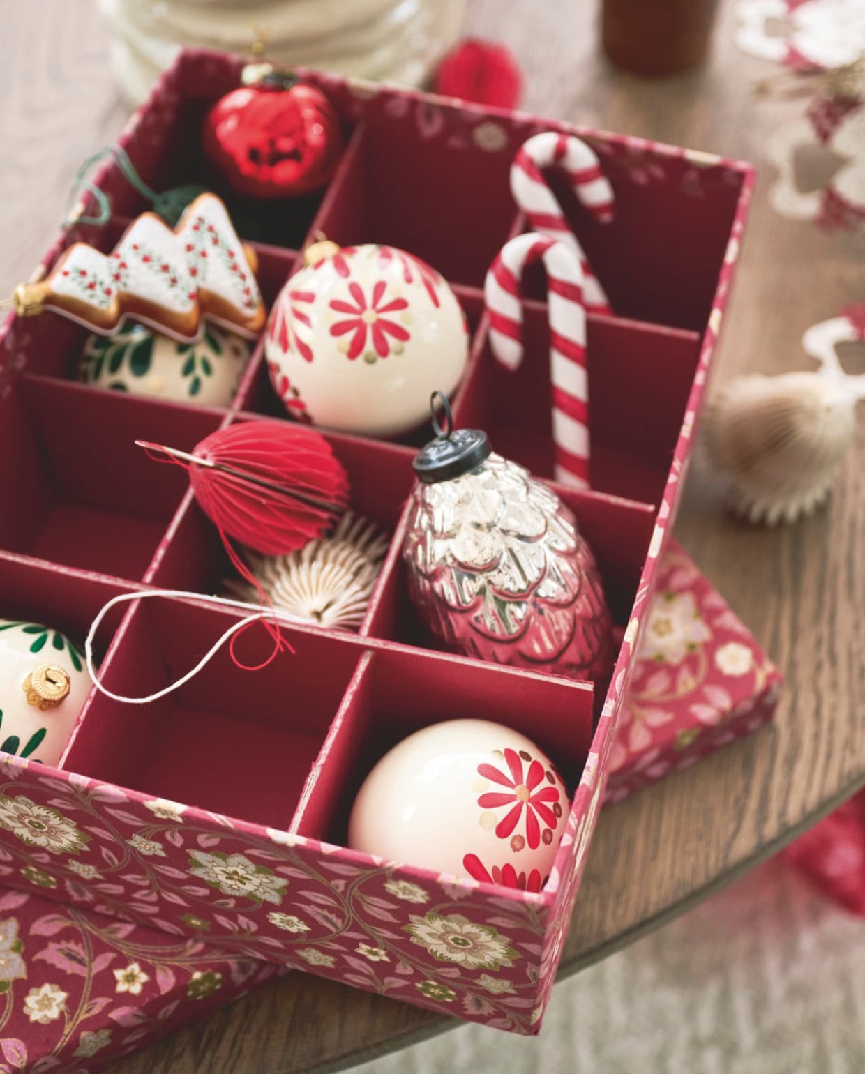 Dagmara kerstballen My Christmas, glas, crème met rode en groene bloemmotieven, set van 4 stuks € 35,90, kerstornament Candy Canes, glas, rood en wit, set van 2 stuks € 15,90 (shop.vtwonen.nl). Bungalow kerstornamenten, appel, glas € 10,-, kerstman, papier, set van 2 stuks € 16,-, ornamenten, papier, wit, set van 3 stuks € 16,25, dennenappels, glas, zilver € 19,- (bungalow.dk). vtwonen kerstspecial 2025 | styling Danielle Verheul | fotografie Sjoerd Eickmans