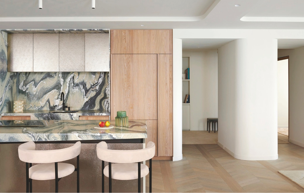 Op maat gemaakte keuken van Framework Studio in kaashout (natuurlijke kleur en gespoten). Details van blauw staal. Hoge kastfronten van geborsteld metaal. Marmeren kookeiland in Cipollino Verde. Verlichting boven kookeiland Kreon. Barkrukken Mobel Copenhagen. Stijlvol wonen 9-2025 | fotografie Kasia Gatkowska