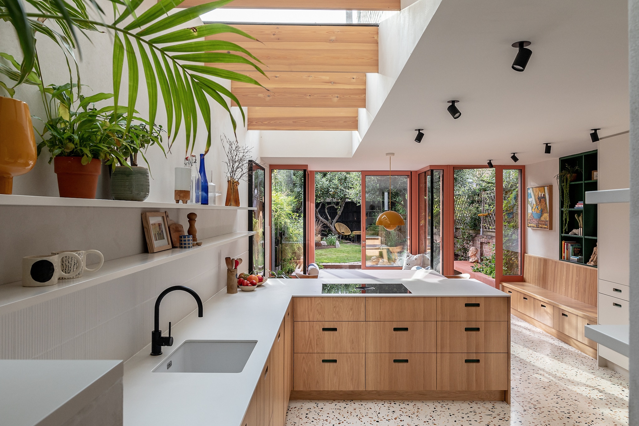 Terrazzovloer Diespeker & Co. Eikenhouten keukenkasten ontworpen door James Dowie van Tactile Things. Aanrechtblad Dekton. Inductiekook-plaat Bora. Kraan Lusso Stone. Kopjes Sos Ceramics. Plafondspots Astro lighting. Ingebouwde kast en muurplanken Tactile Things. Bank The Conran Shop. Hanglamp Flowerpot van &Tradition. Schilderij Johanna Ward. vtwonen 02-2026 | fotografie Taran Wilkhu | productie Living Inside