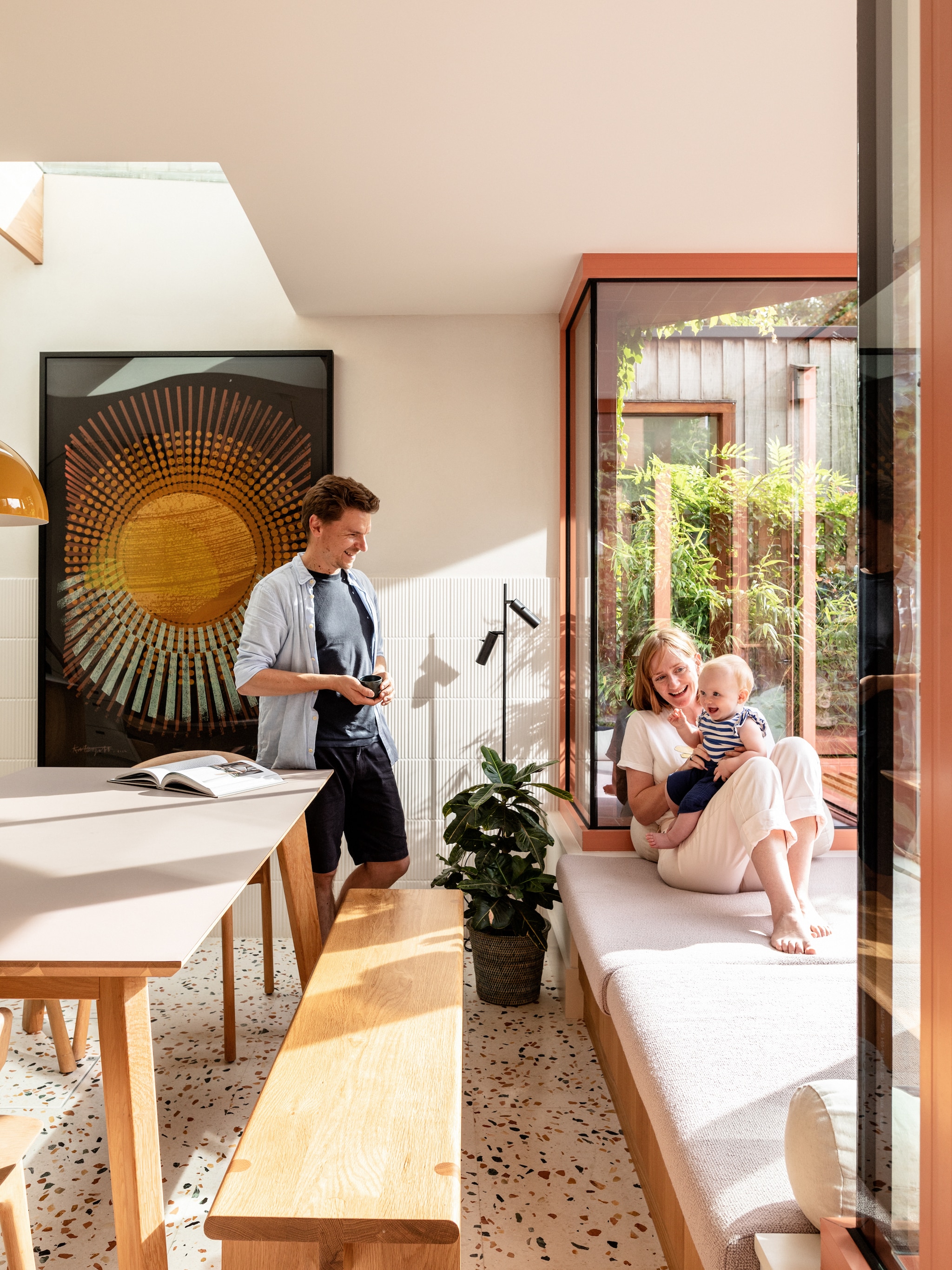 Eikenhouten bank ontworpen door meubelmaker James Dowie van Tactile Things. Tafel en stoelen Ethnicraft. Kussens Ferm living en Hay. Staande lamp Cato Slim van Belid. Zeefdruk Island Life van Kate Gibb. Structuurtegels Flaunt van Parkside. vtwonen 02-2026 | fotografie Taran Wilkhu | productie Living Inside