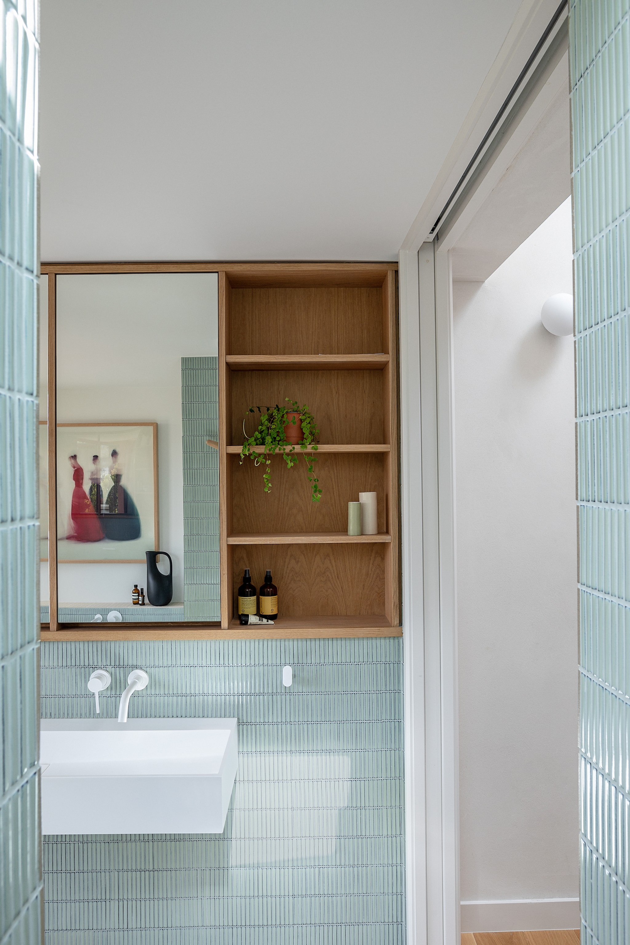 Wastafel en kranen Lusso stone. Badkamermeubel James Dowie. Schilderij Kate Gibb. Tegels Iggy Sage Gloss Porcelain van Mandarin stone. vtwonen 02-2026 | fotografie Taran Wilkhu | productie Living Inside