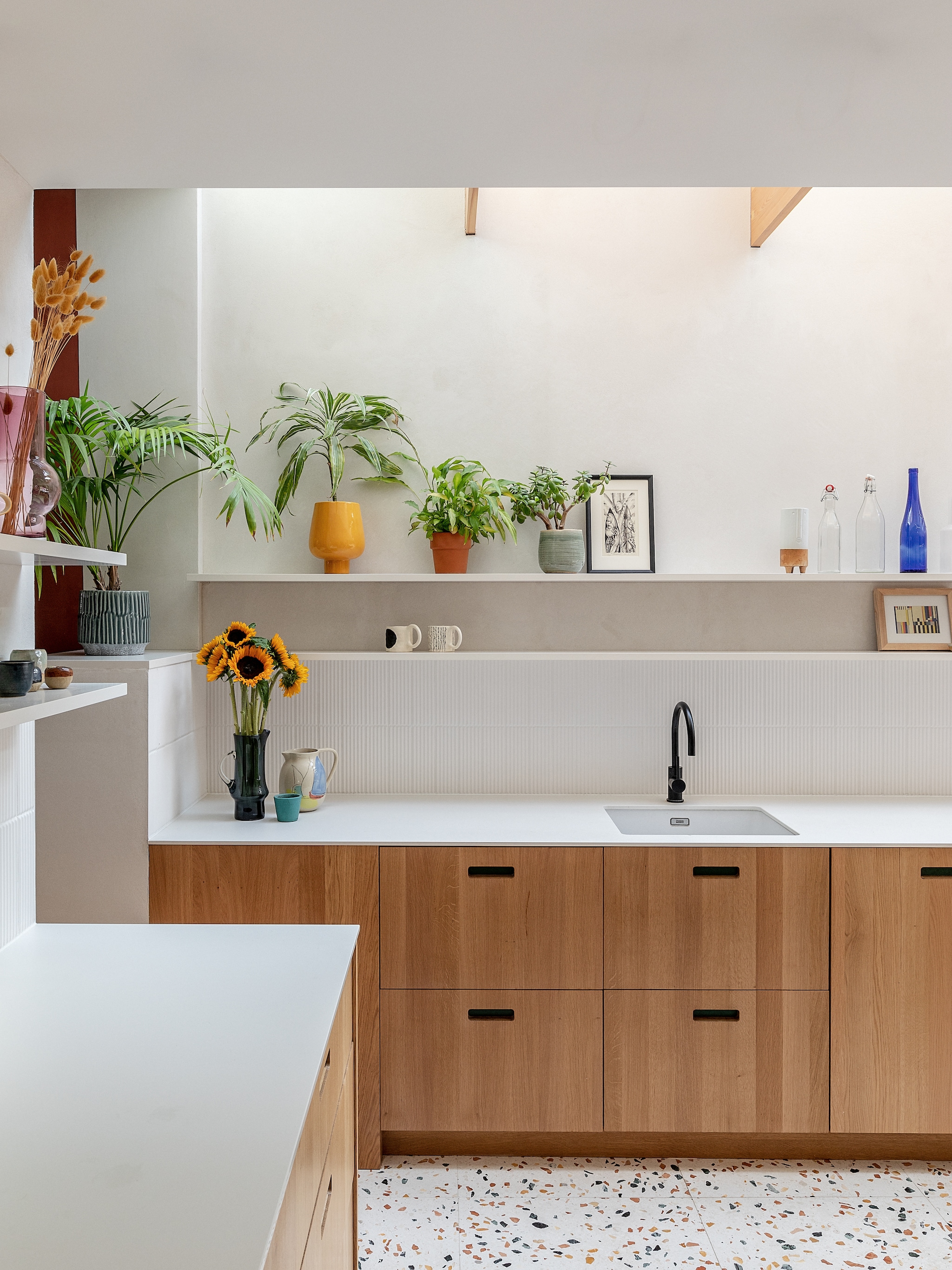 Eikenhouten keukenkasten en wandplanken ontworpen door James Dowie van Tactile Things. Print Michel Tuffery. Kopjes Sos Ceramics. vtwonen 02-2026 | fotografie Taran Wilkhu | productie Living Inside