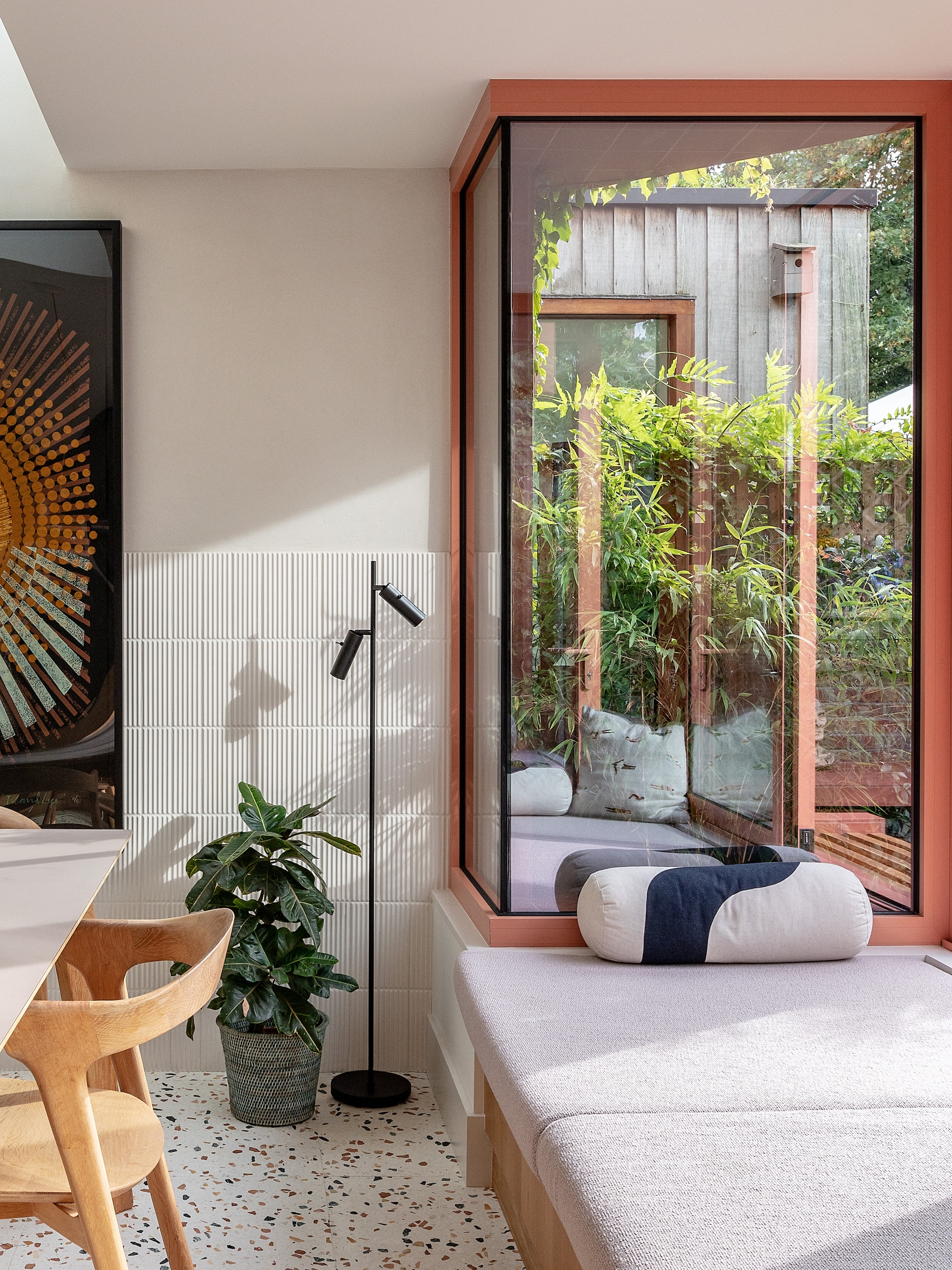 Eikenhouten bank ontworpen door meubelmaker James Dowie van Tactile Things. Tafel en stoelen Ethnicraft. Kussens Ferm living en Hay. Staande lamp Cato Slim van Belid. Zeefdruk Island Life van Kate Gibb. Structuurtegels Flaunt van Parkside. vtwonen 02-2026 | fotografie Taran Wilkhu | productie Living Inside