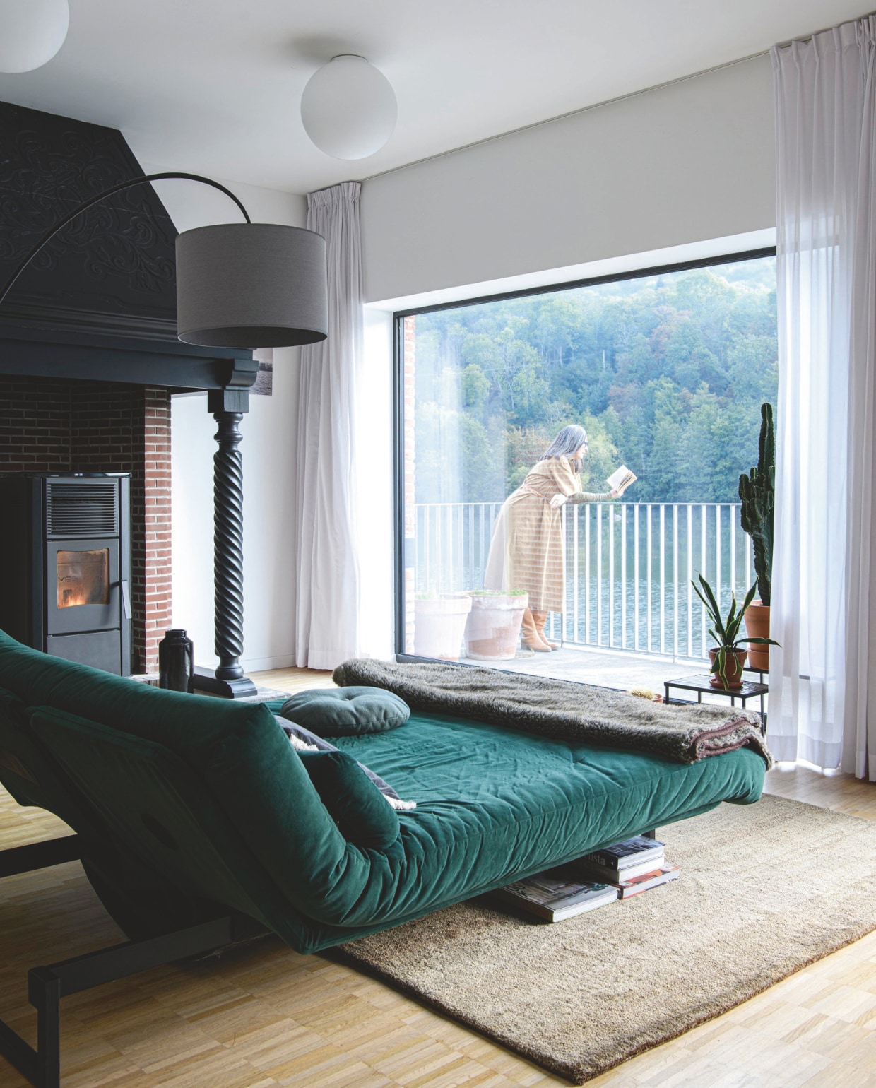 Daybed Innovation Living. Bijzettafels vintage. Plafondlampen en staande lamp Zangra. Gordijnen Hema. Kachel zat al in het huis. vtwonen 12-2025 | styling Marit Saladini | fotografie Louis Lemaire