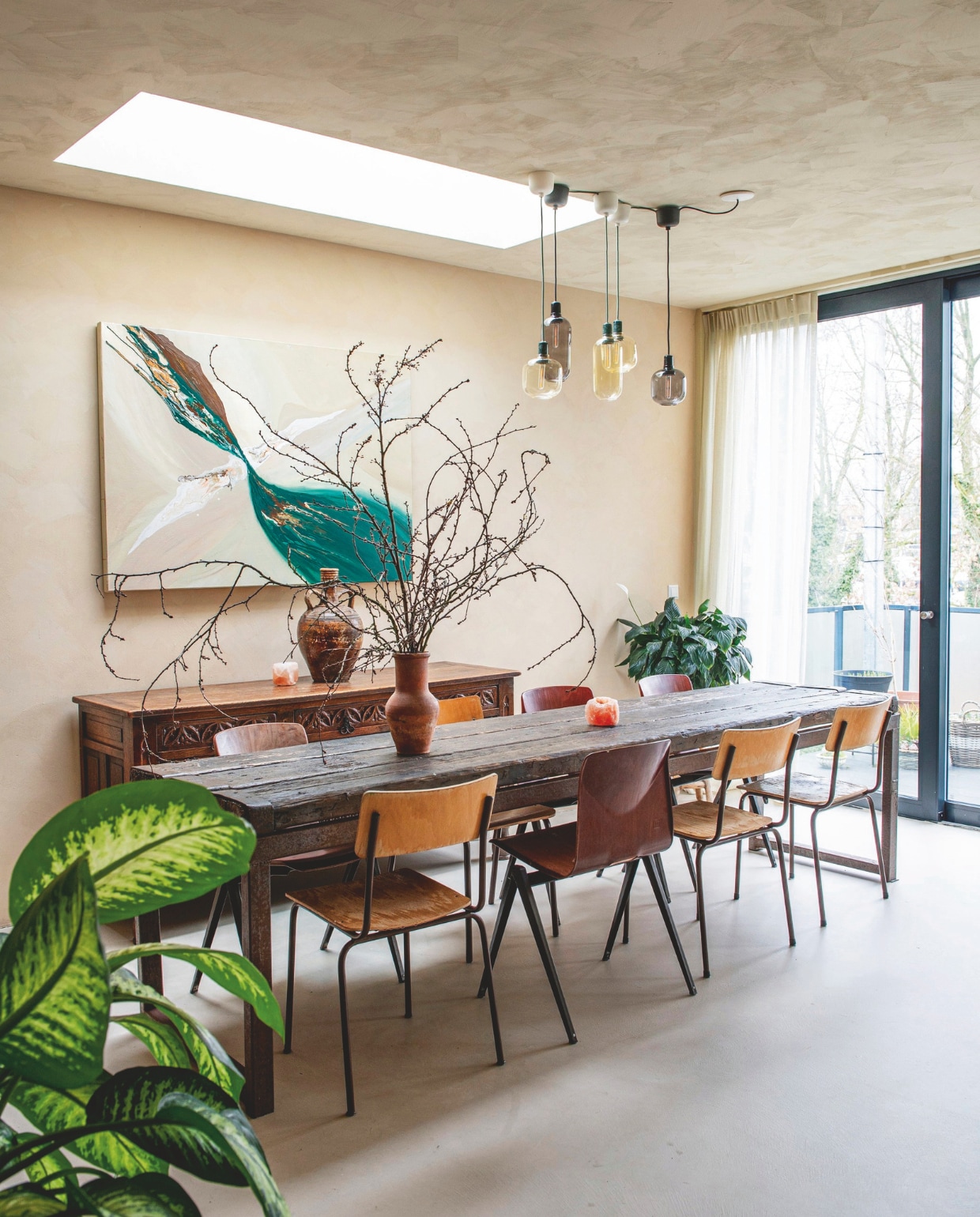 Dakraam ingebouwd door aannemer. Tafel en stoelen kringloop. Lampen Sklum. Oude kloosterkast kringloop. Waxinelichthouder zoutsteen Fabula Rosa. Kunstwerk zelf gemaakt. vtwonen 12-2025 | styling Annemieke Paarlberg | fotografie Caroline Coehorst | tekst Ina Babbé