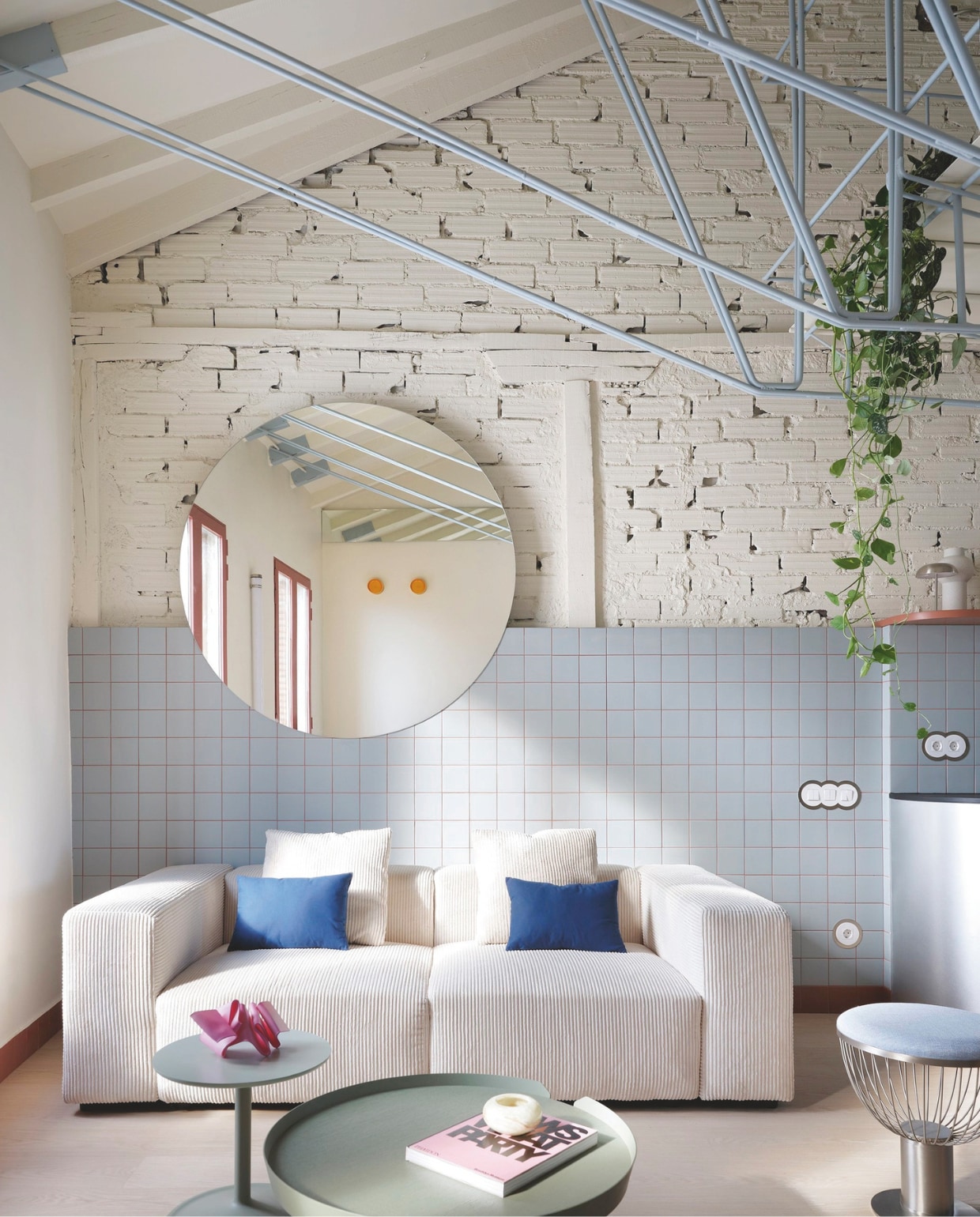 Bank Sklum. Blauwe kussens Zara Home. Kruk Emma van Momocca. Salontafel Around en bijzettafel Soft Side van Muuto. Alles via Espacio Betty. Sculpturen Iria Martínez.