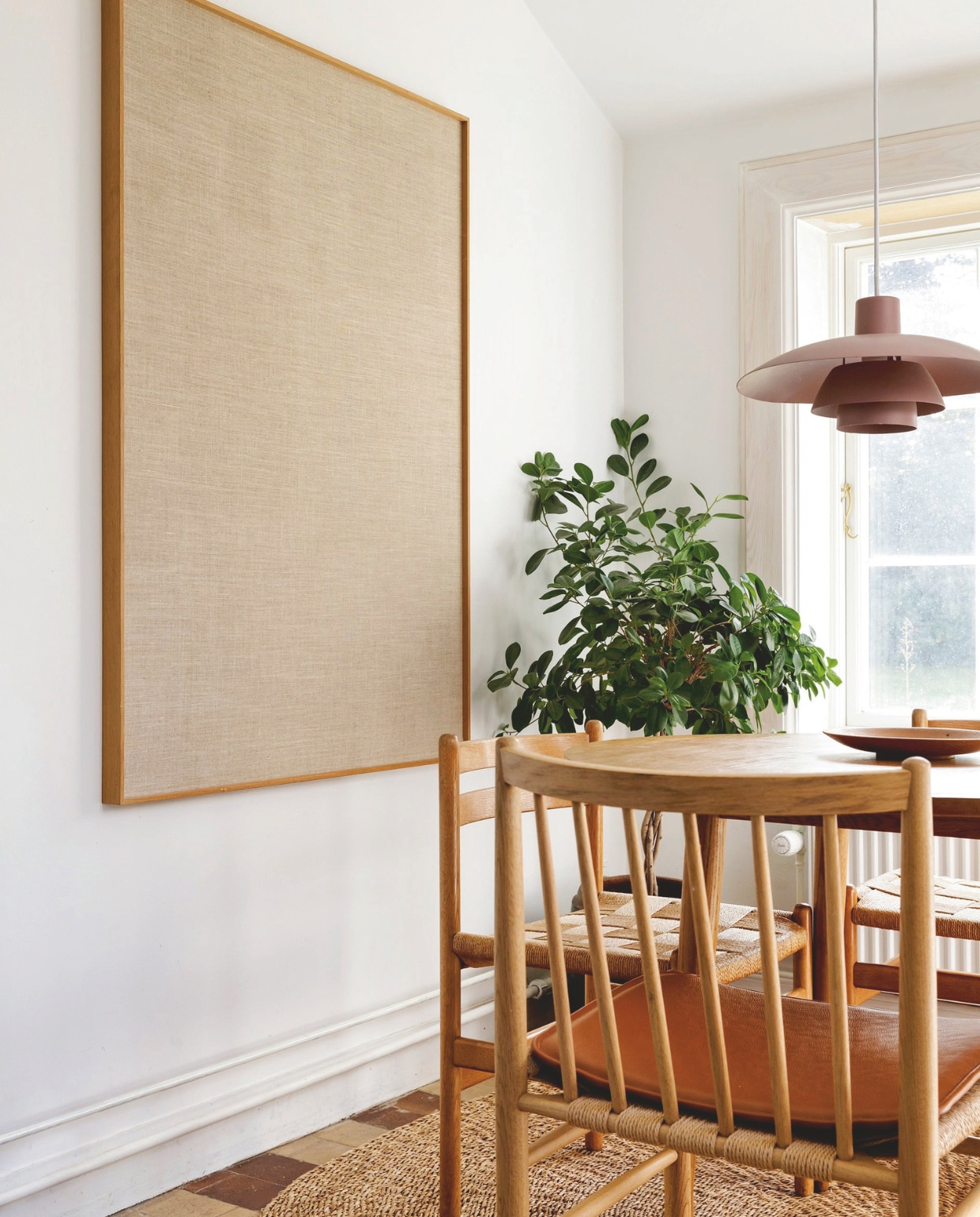 Hanglamp PH5 van Louis Poulsen. Tafel No78. Stoelen Jørgen Bækmark. Aan de wand hangt een groot prikbord. vtwonen 02-2026 | styling Rikke Graff Juel | fotografie Christina Kayser O.