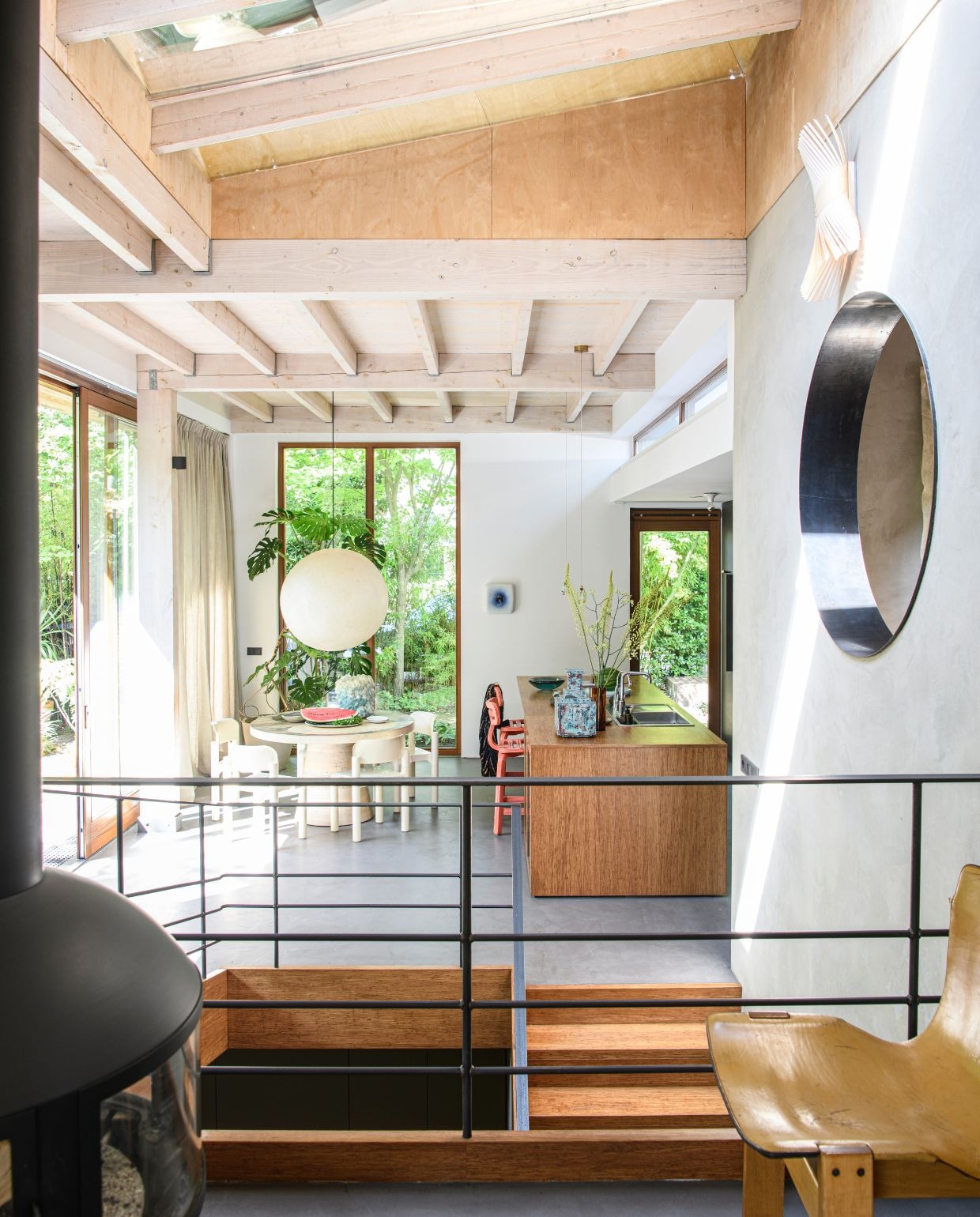 Pandomo cementvloer. Keuken maatwerk door meubelmakerij Het Woud. Eettafel Jacqueline le Bleu. Vintage stoelen Eero Aarnio voor Upo Furniture. Hanglamp vintage. Vaas Isaac Monté. Barkrukken Dirk van der Kooij. Vaas op keukeneiland Studio Fabius Clovis. Keramieken kunstwerk Wil van Blokland. vtwonen 03-2026 | styling Marit Saladini | fotografie Louis Lemaire