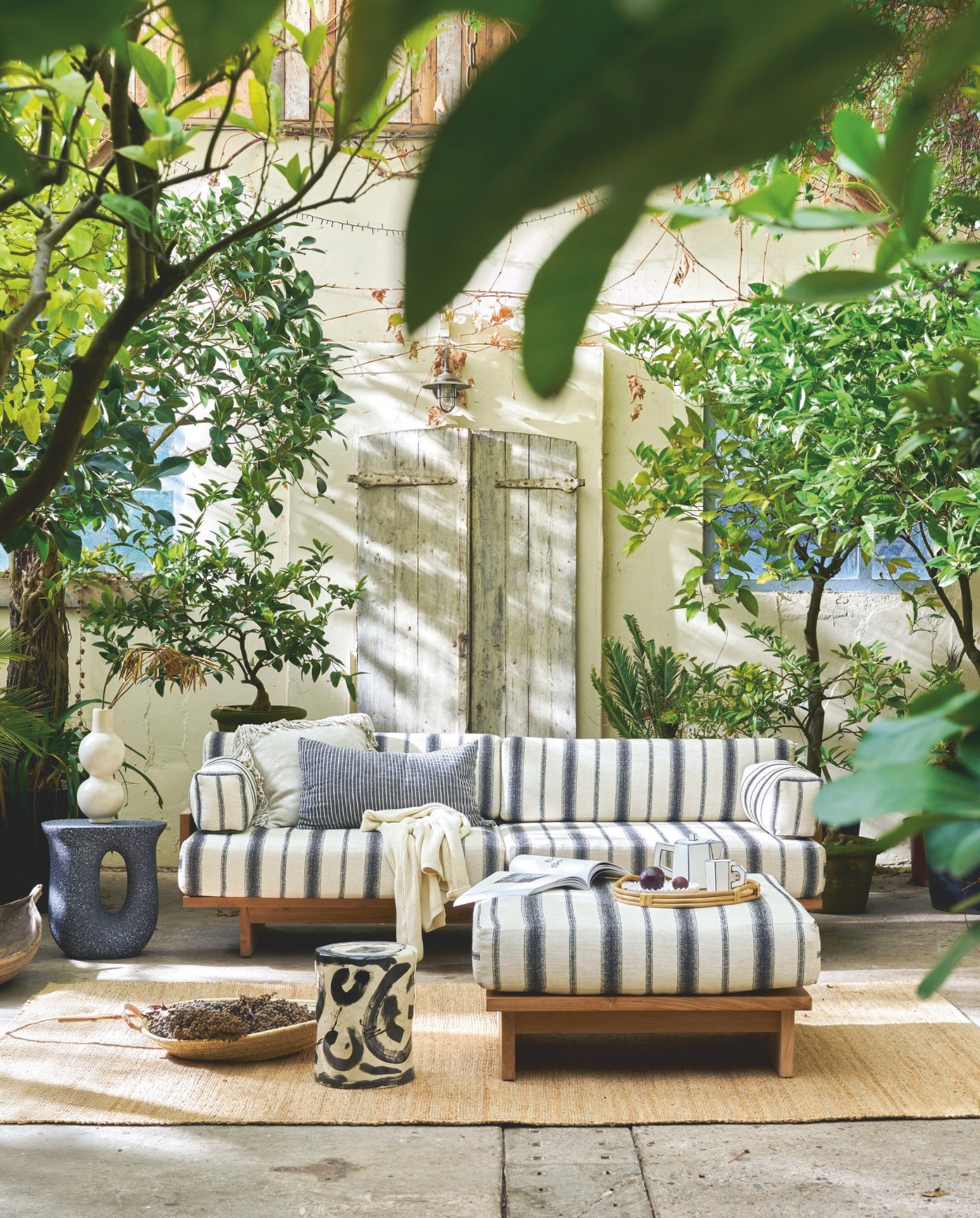 HKliving outdoor loungebank Chalkstripe, teak, 227x93,5x67 cm (bxdxh) € 3295,-, outdoor hocker Chalkstripe, teak, 88x88x38cm (bxdxh) € 995,-, vloerkleed, jute naturel, 340x240 cm (lxb) € 329,-, kussen Monochrome, linnen/katoen, gestreept zwart-wit € 54,90, Household Hardware platte mand Marrakech, riet, L € 65,-, vaas Bubble, tadelakt € 115,-, Woood bijzettafel Mason, magnesium, zwart gespikkeld, 42x33x45 cm (lxbxh) € 99,95 (shop.vtwonen.nl). Omar buitenkussen Oat, met franjes, beige, inclusief vulling € 210,- (omar-antwerp.be). Serax bijzettafel 06 Sophia Pawn, keramiek, zwart-wit, 27x34 cm (Øxh) € 190,-, theepot Carte Blanche, porselein € 45,-, beker Carte Blanche, porselein € 22,- (serax.com). Zara Home dienblad, rotan € 49,99 (zarahome.com). Overig privébezit.