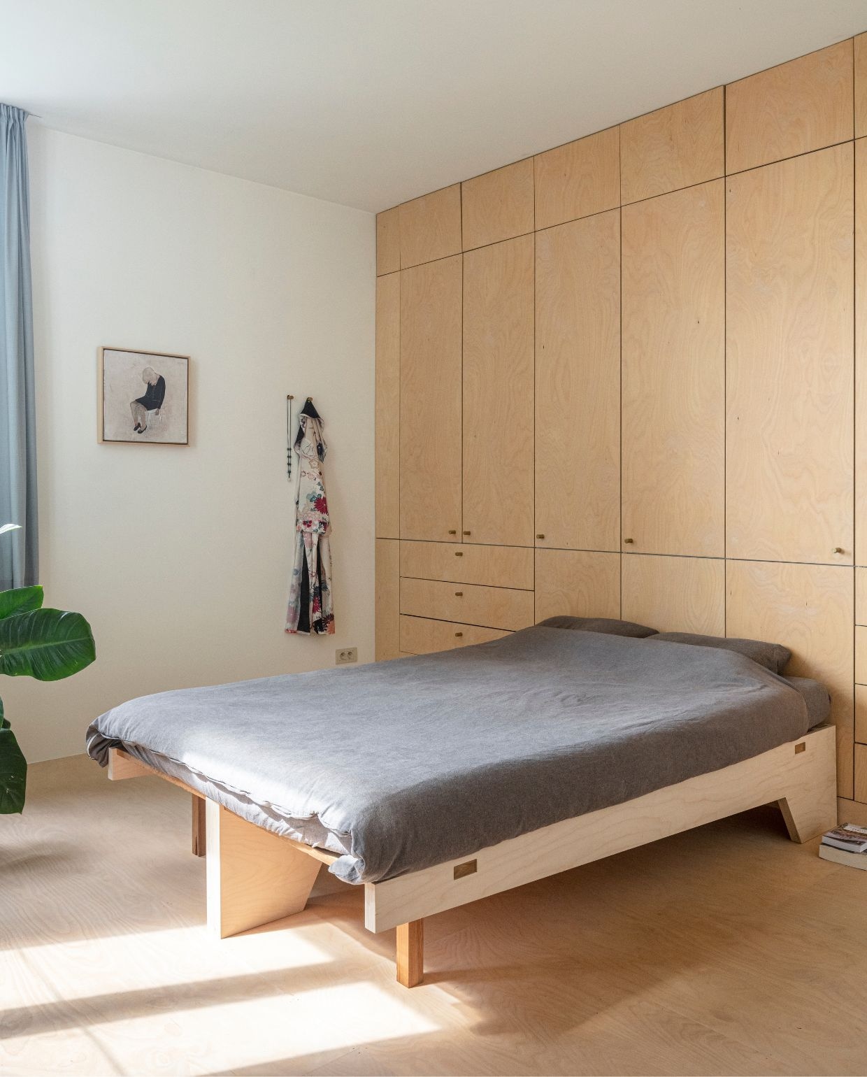 Vloer en kast zelfgemaakt van multiplex berk. Bed Atelier Janda Vanderghote. Dekbedovertrek Muji. Kunstwerk Yves Velter. vtwonen 03-2026 | fotografie Tim van de Velde