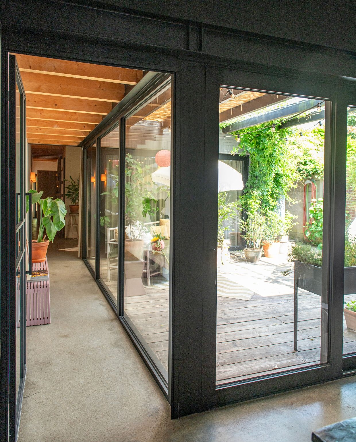 Een aluminium raampartij creëert de patio. Kruidenbak Lidl. De weelderige klimplant is passiflora. vtwonen 03-2026 | fotografie Caroline Coehorst