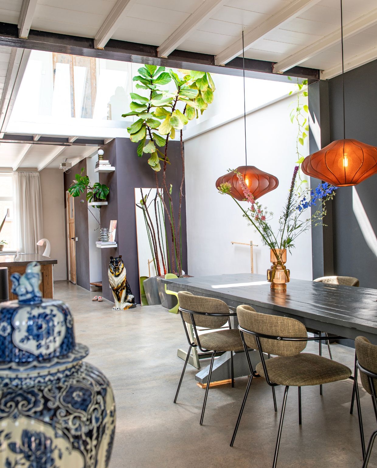 Vintage vaas. Eettafel gemaakt door Vincent. Stoelen en kleine lamp Kwantum. Hanglampen Lampenlicht.nl. Keramieken hond vintage. Tabaksplant via Marktplaats. Wandplankjes Ikea. Vaas Karwei. Tafellamp Swan van Eero Aarnio. vtwonen 03-2026 | fotografie Caroline Coehorst