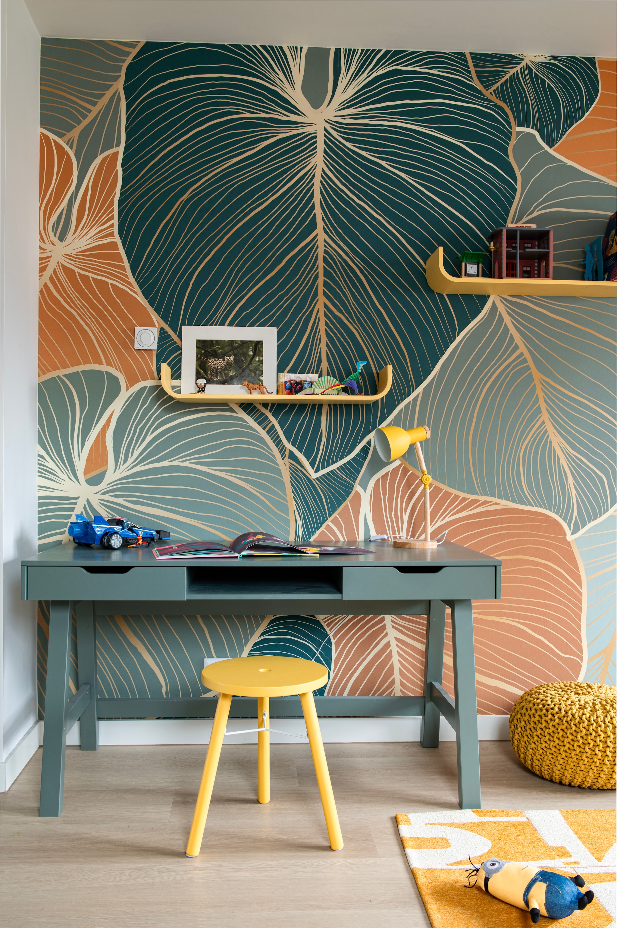 Behang bladeren met koper van Fotobehang.com. Bureau Nikki van Woood. Kruk Kinna van Jotex. Poef Bisho van La Redoute. Wandplanken Flower van Tenzo. Bureaulamp Rpixc via Amazon. vtwonen 07-2026 | fotografie Caroline Coehorst