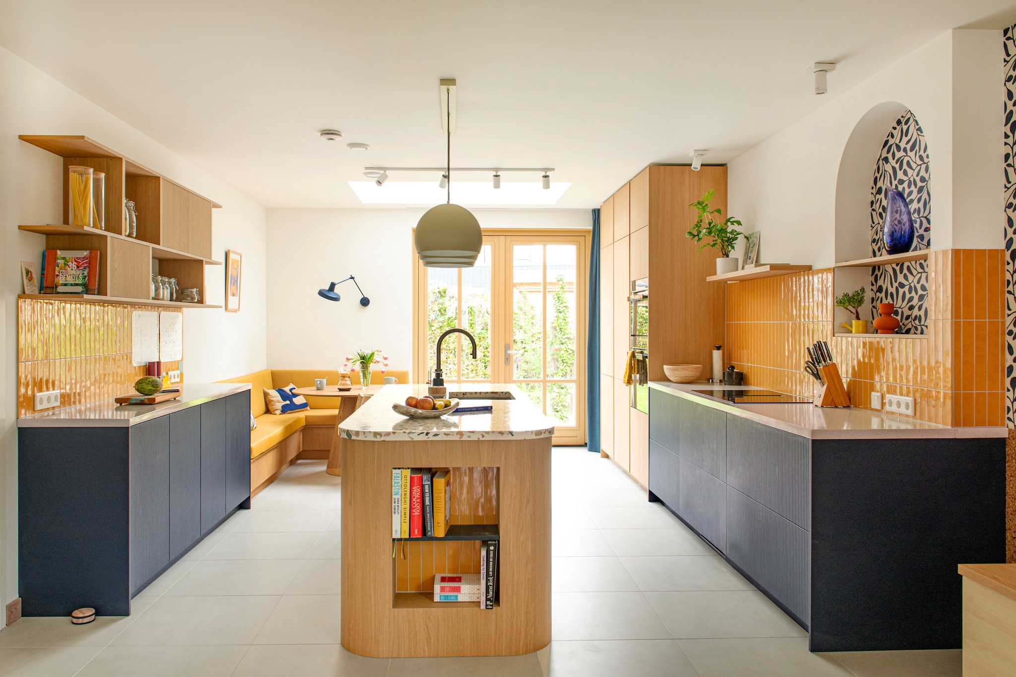 Keuken en bank Jorik Maakt. Tegels Luz Giallo van Marazzi.  Plafondlamp Jaicey van Light & Living. Maatkussen bank in Linnenlook Yellow door Nofruit. Wandlamp Arigato van Grupa. Muurkleur Wevet van Farrow & Ball. vtwonen 07-2026 | fotografie Caroline Coehorst