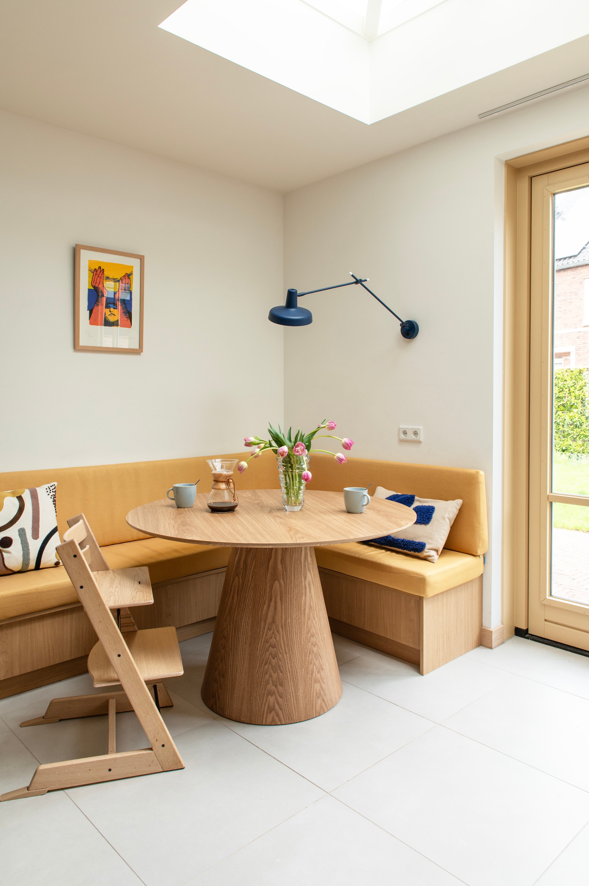 Bank maatwerk van Jorik Maakt. Maatwerk kussen in Linnenlook Yellow door Nofruit. Kussens Westwing en Ferm Living. Stoel Stokke. Kunstprint Fernando Carballo. Lamp Arigato van Grupa. Mokken Ikea. Muurkleur Wevet van Farrow & Ball. vtwonen 07-2026 | fotografie Caroline Coehorst